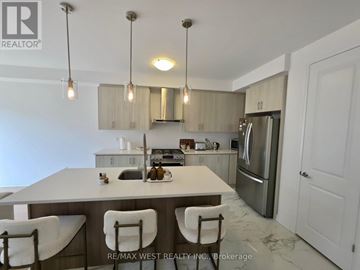 Stratford townhouse for rent - A kitchen with a table and chairs in the foreground and a refrigerator in the background.