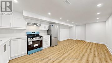 Markham (Aileen-Willowbrook) apartment for rent - A kitchen with white cabinets and a blue stove top oven.