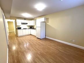 Surrey apartment for rent - A kitchen area with wooden flooring and white appliances.
