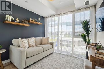 Innisfil condo for rent - A living room with a grey couch and a large window.