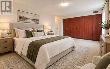 Brampton (Queen Street Corridor) condo for rent - A bedroom with a large bed and a painting on the wall.