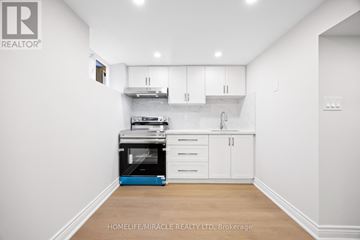 Toronto (Bendale) apartment for rent - A white kitchen with a blue oven and white cabinets.