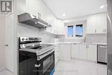 Toronto (Bendale) apartment for rent - A modern kitchen with white cabinets and a black stove top oven.