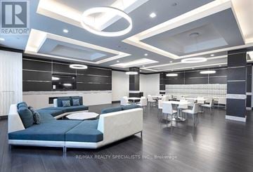Vaughan (East Woodbridge) condo for rent - A modern living room with a blue sofa and a dining table.