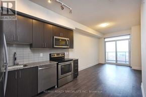 Vaughan (East Woodbridge) condo for rent - A kitchen with dark wood cabinets and stainless steel appliances.