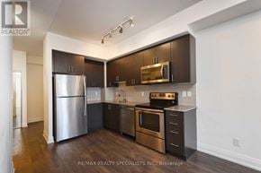 Vaughan (East Woodbridge) condo for rent - A modern kitchen with dark wood cabinets and stainless steel appliances.