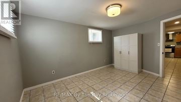 Wasaga Beach apartment for rent - A room with a tiled floor and a white door leading to another room.