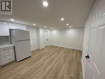 Richmond Hill (Crosby) apartment for rent - A kitchen with white cabinets and a refrigerator.