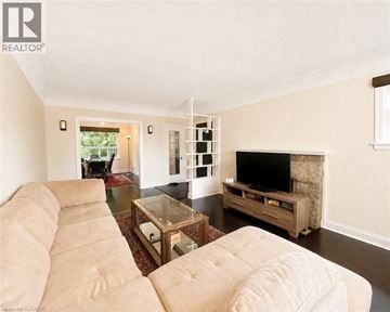 Hamilton apartment for rent - A living room with a beige couch and a television.