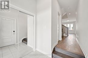 Ottawa townhouse for rent - A white hallway with a door on the left and a wooden floor.
