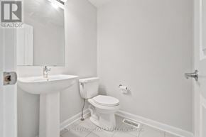 Ottawa townhouse for rent - A white bathroom with a sink, toilet and a mirror.