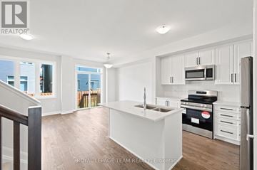 Ottawa townhouse for rent - A white kitchen with a stove top oven and microwave.