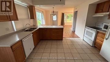 Innisfil apartment for rent - A kitchen with wooden cabinets and a white dishwasher.
