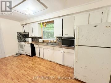 Richmond Hill (Harding) apartment for rent - A kitchen with white cabinets and a wooden floor.
