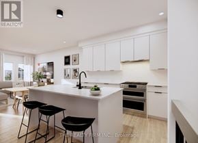 London South (South U) townhouse for rent - A modern kitchen with white cabinets and black bar stools.