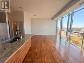 Mississauga (City Centre) condo for rent - A spacious room with wooden floors and large windows overlooking a cityscape.