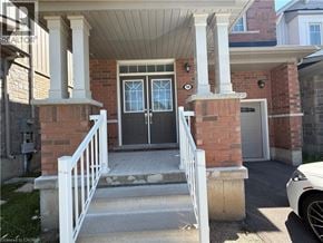 Niagara Falls apartment for rent - A house entrance with a white railing and a black door.