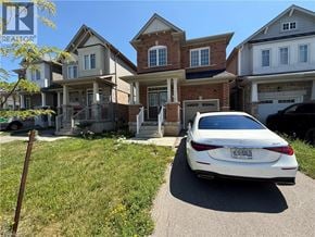 Niagara Falls apartment for rent - A white car is parked in front of a house with a garage.