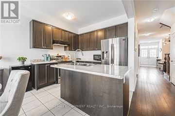 Hamilton (Binbrook) apartment for rent - A modern kitchen with dark wood cabinets and stainless steel appliances.