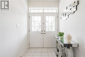 Hamilton (Binbrook) apartment for rent - A white door with a glass window is in the middle of a hallway.