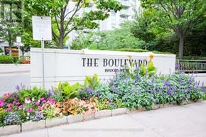 Toronto (Willowdale East) condo for rent - The Boulevard sign is on a white fence surrounded by flowers.