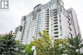 Toronto (Willowdale East) condo for rent - A tall residential building with balconies and a sign for Achievement Realty Corporation Brokerage.