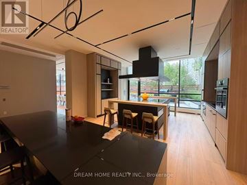 Toronto (North St. James Town) condo for rent - A modern kitchen with a black table and wooden cabinets.