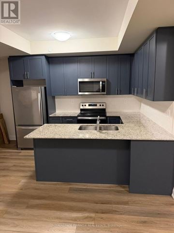 Milton (Cb Cobban) townhouse for rent - A kitchen with a granite countertop and a refrigerator.