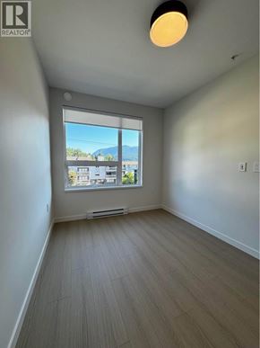 Port Moody apartment for rent - A room with a window overlooking a cityscape.