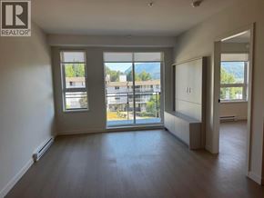Port Moody apartment for rent - A spacious room with a view of the outdoors through large windows.
