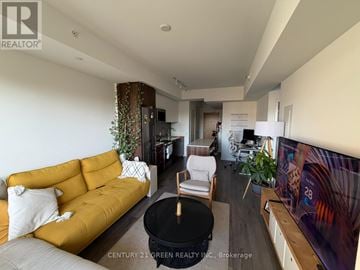Toronto (Weston-Pellam Park) condo for rent - A living room with a yellow sofa and a black coffee table.