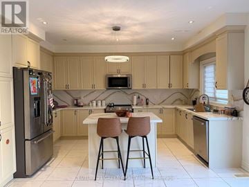 Brampton (Bram West) apartment for rent - A kitchen with a refrigerator, a table and chairs, and a microwave.