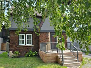 Niagara Falls (Dorchester) apartment for rent - A house with a brick exterior and a deck with stairs leading up to the front door.