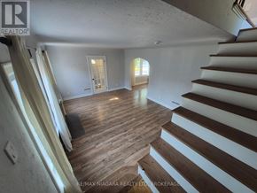 Niagara Falls (Dorchester) apartment for rent - A wooden floor in a house with a staircase on the right side.