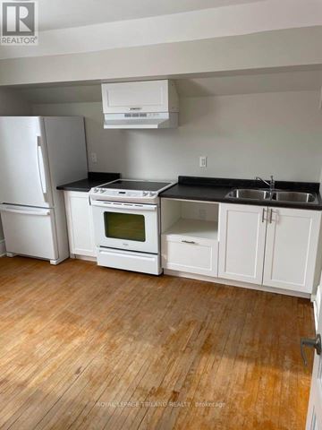St. Thomas multi-family for rent - A kitchen with white appliances and cabinets.