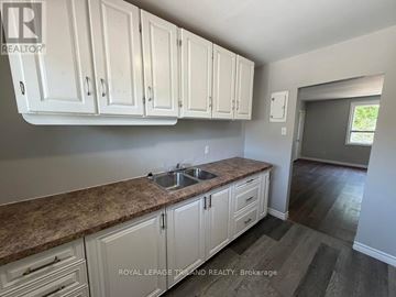 London East (East K) multi-family for rent - A kitchen with white cabinets and a granite countertop.