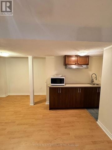Mississauga (Churchill Meadows) apartment for rent - A room with a wooden floor and a kitchenette with a microwave and a sink.