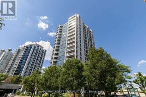 Toronto (Mimico) condo for rent - A tall building with many windows stands in front of a sky with clouds.