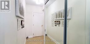 Toronto (Mimico) condo for rent - A hallway with a white door and a wall with a picture and a sign that says RE/MAX Realty Specialists Inc. Brokerage.