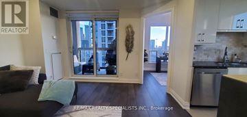 Toronto (Mimico) condo for rent - A living room with a couch and a large window.
