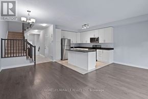 Ottawa townhouse for rent - A spacious kitchen and living room with white cabinets and a staircase.