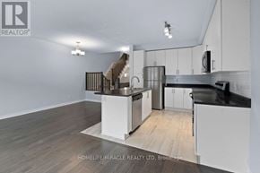 Ottawa townhouse for rent - A modern kitchen with white cabinets and stainless steel appliances.