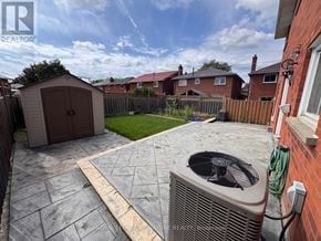 Toronto (West Humber-Clairville) apartment for rent - A backyard with a patio, a shed, and a wall-mounted air conditioning unit.