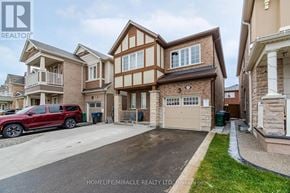 Brampton (Northwest Brampton) apartment for rent - A red SUV is parked in a driveway in front of a house.