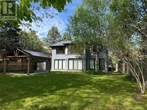 Mississauga (Erin Mills) apartment for rent - A house with a green lawn and trees in the background.