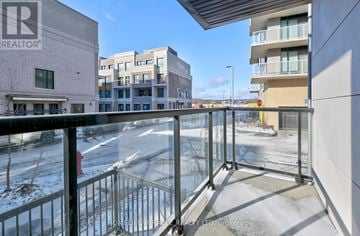 Richmond Hill townhouse for rent - A view from a balcony overlooking a parking lot and buildings.