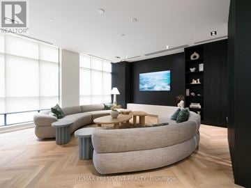 Brampton (Fletcher's Creek South) condo for rent - A living room with a large grey sofa and a wooden coffee table.