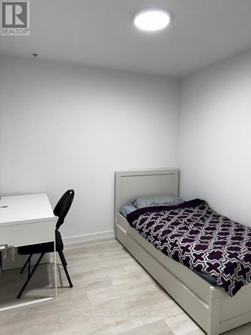Hamilton (Corktown) condo for rent - A bedroom with a bed, desk, and chair.