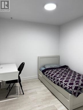 Hamilton (Corktown) condo for rent - A bedroom with a bed, desk, and chair.
