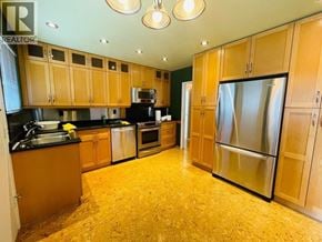 Coquitlam apartment for rent - A kitchen with wooden cabinets and a refrigerator.
